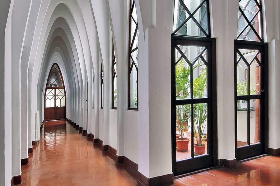 Pasillo de arcos parabólicos blancos en el Colegio de las Teresianas